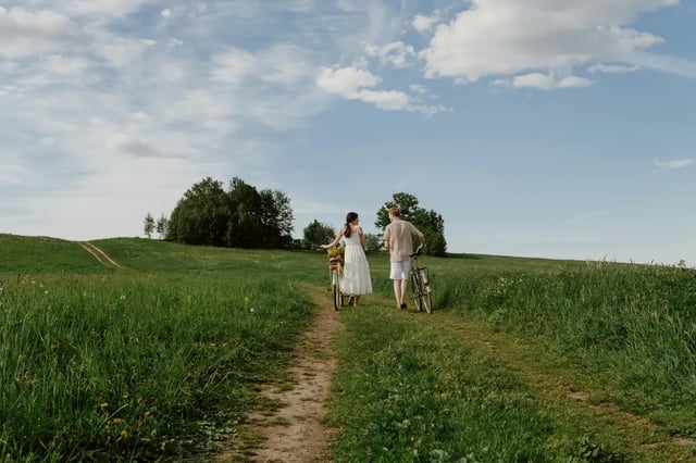 Couple pushing bicycles along a country lane